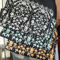 Women's black floral-vine embroidered shawls photographed in several thread colors