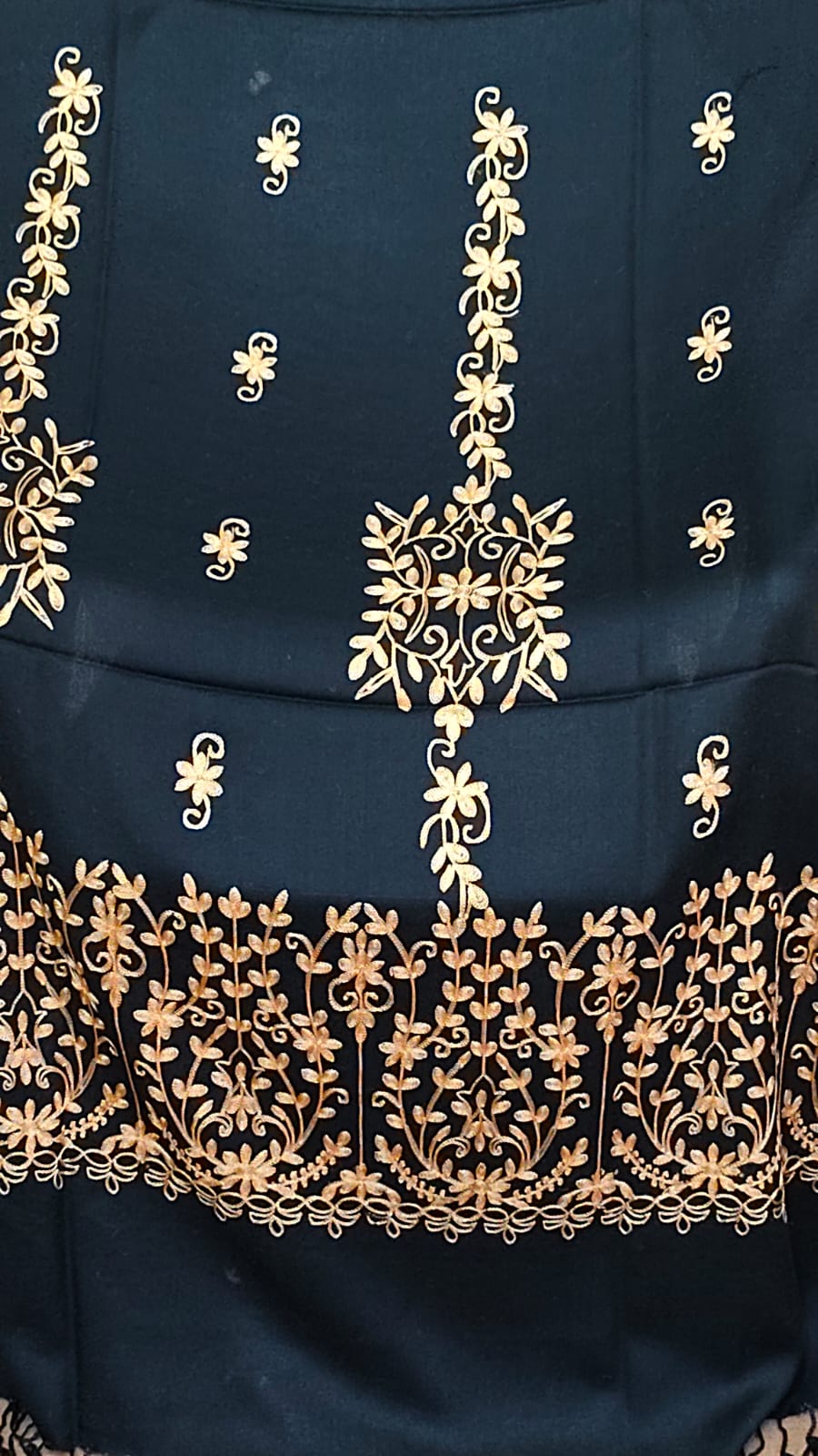 Detailed gold floral embroidery and border on a black shawl