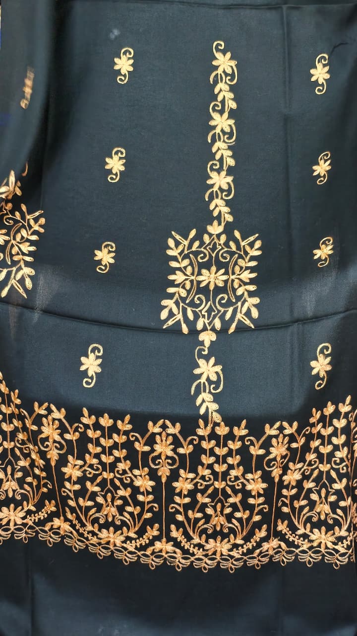 Close-up of gold botanical floral embroidery on black shawl